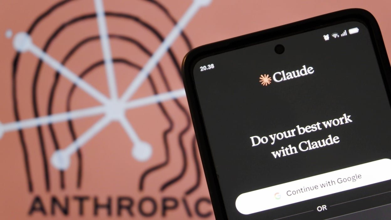 An Anthropic logo behind an iPhone logging into Claude