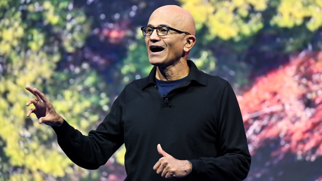 Satya Nadella on stage with a colorful background
