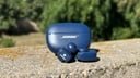 blue bose ultra open earbuds on wall in front of greenery