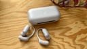 purple soundcore aerofit 2 pro earbuds on case on wood tabletop